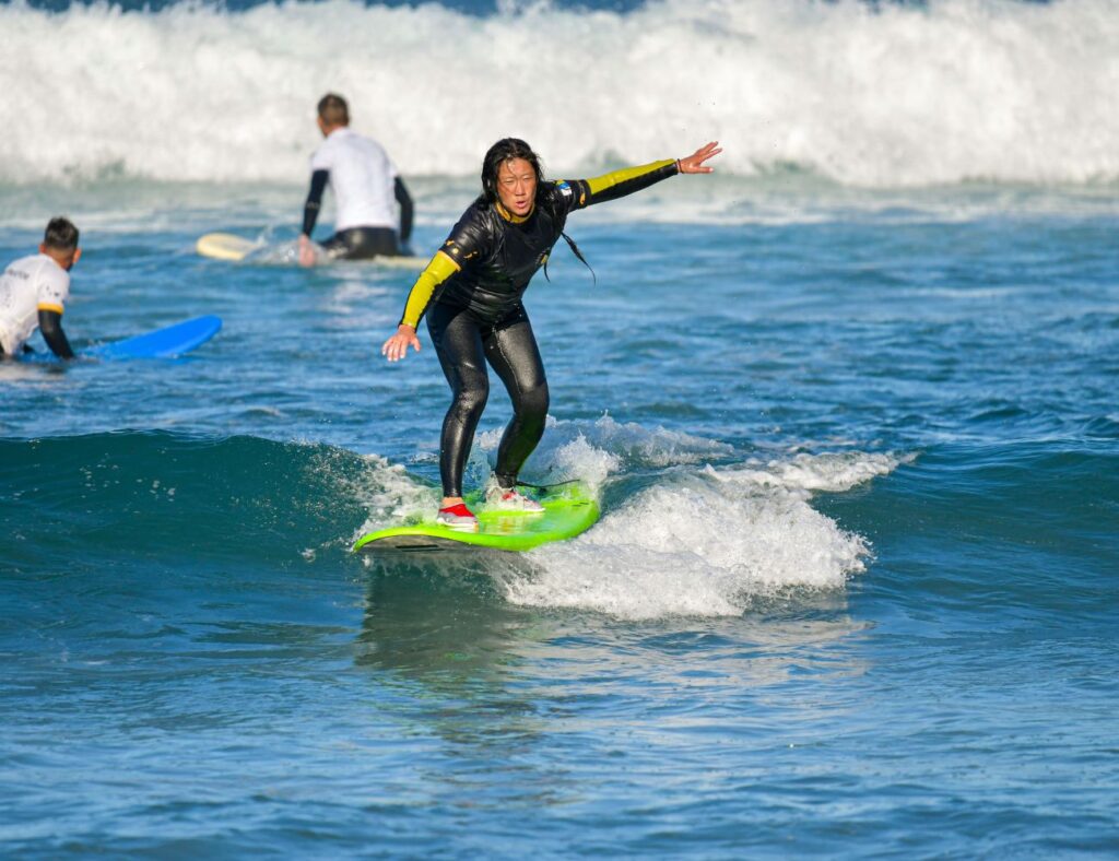 beginner group entering surf spot for the surfing lesson in Playa de Las Americas