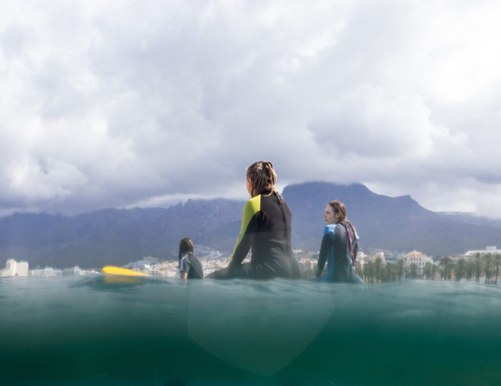 beginner group entering surf spot for the surfing lesson in Playa de Las Americas